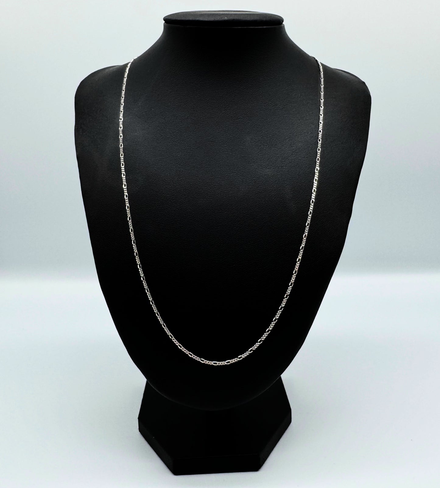 Elegante Figaro-Kette aus 925er Silber mit Diamond-Cut, präsentiert auf einer schwarzen Leder-Schmuckpuppe. Hochwertige, filigrane Glieder mit polierter Oberfläche sorgen für einen edlen Look. Diese Silberkette ist sowohl für Damen als auch Herren geeignet und ideal als modisches Accessoire oder Geschenk. Perfekt für den Alltag oder besondere Anlässe.