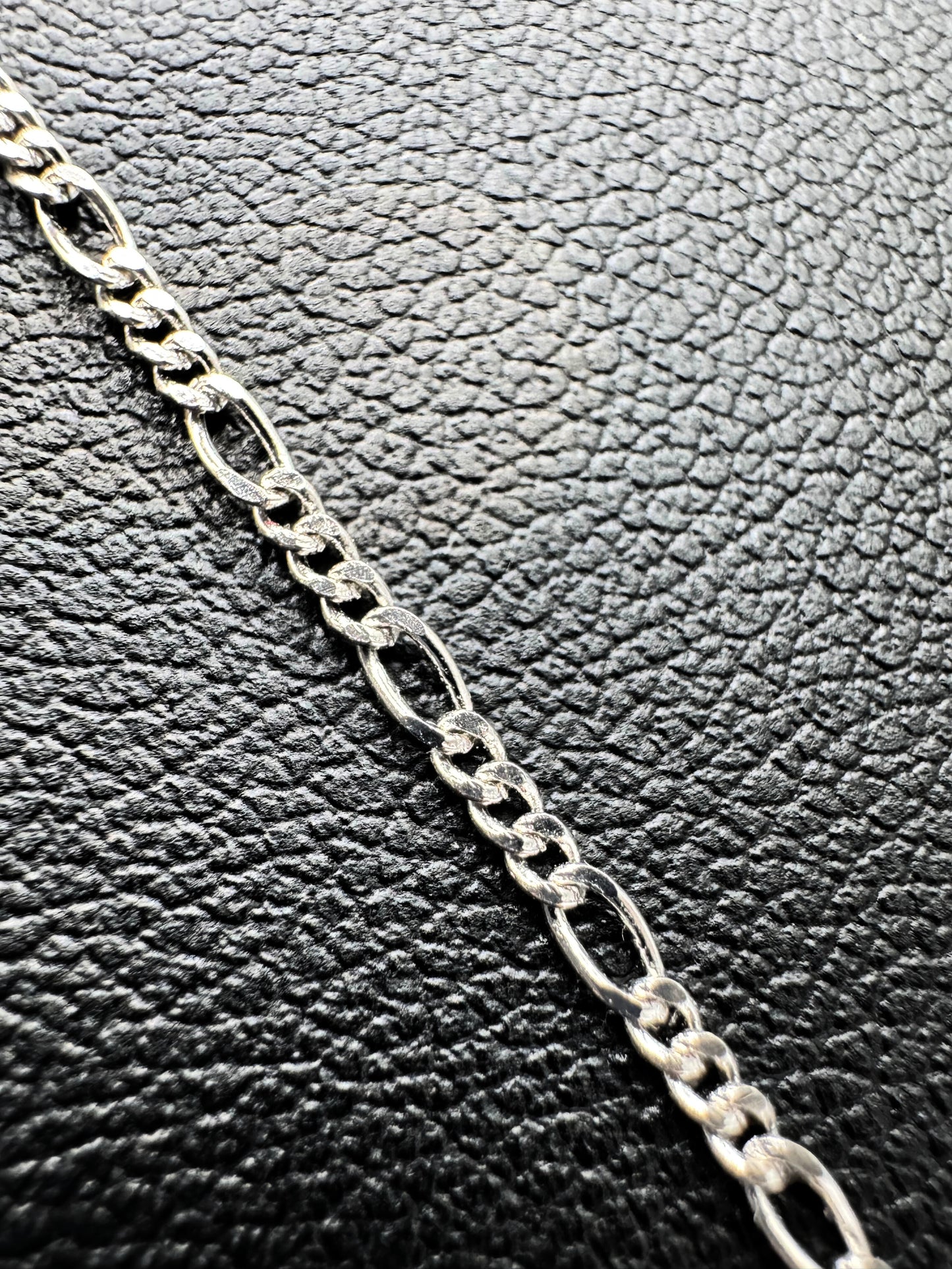 Elegante Figaro-Kette aus 925er Silber mit Diamond-Cut, präsentiert auf einer schwarzen Leder-Schmuckpuppe. Hochwertige, filigrane Glieder mit polierter Oberfläche sorgen für einen edlen Look. Diese Silberkette ist sowohl für Damen als auch Herren geeignet und ideal als modisches Accessoire oder Geschenk. Perfekt für den Alltag oder besondere Anlässe.
