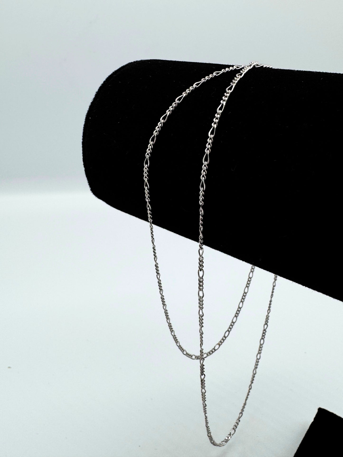 Feine Figaro-Kette aus 925er Sterling Silber mit hochwertigem Diamond-Cut, präsentiert auf einer edlen schwarzen Samthalterung. Die glänzende, filigrane Gliederkette überzeugt mit ihrem zeitlosen Design und luxuriösem Finish. Perfekt als modisches Accessoire für Damen und Herren, ideal für den Alltag oder besondere Anlässe.