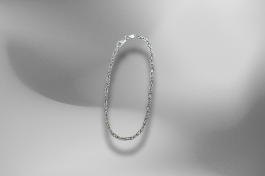 Elegante 925er Sterling Silber Byzantiner Königskette, schwebend auf einem sanften, grau-schattierten Hintergrund. Die massive Silberkette, eine hochwertige Byzantinerkette, wird freigestellt präsentiert und wirft einen weichen Schatten auf den monochromen Hintergrund. Hochwertige Königskette, zeitlose Byzantinerkette, massive Silberkette, edle Halskette, Schmuckstück, Silberkette, Herrenkette, Luxus-Accessoire, elegante Halskette, Schmuck-Fotografie.

