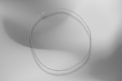 Feine Figaro-Kette aus 925er Sterling Silber mit Diamond-Cut, präsentiert auf einem modernen, silberfarbenen Hintergrund mit weichen Lichtreflexen. Die zarte Gliederkette besticht durch ihr elegantes Design und ihren edlen Glanz. Ideal für Damen und Herren, perfekt als stilvolles Accessoire für den Alltag oder besondere Anlässe.