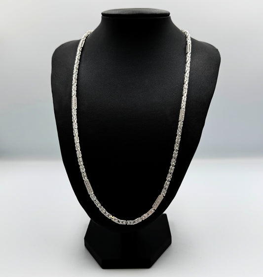 Funkelnde 925er Sterling Silberkette im "Iced Out" Stil, eine luxuriöse Königskette für Herren und Damen. Die Kette ist kunstvoll gearbeitet und mit glitzernden Zirkonia-Steinen besetzt, die für einen auffälligen und edlen Look sorgen. Präsentiert wird die Silberkette auf einer eleganten, schwarzen Leder-Schmuckpuppe vor einem klaren, weißen Hintergrund. Diese hochwertige Königskette aus echtem Sterlingsilber ist ein exklusives Schmuckstück, das jedes Outfit aufwertet. Die Kette ist massiv.