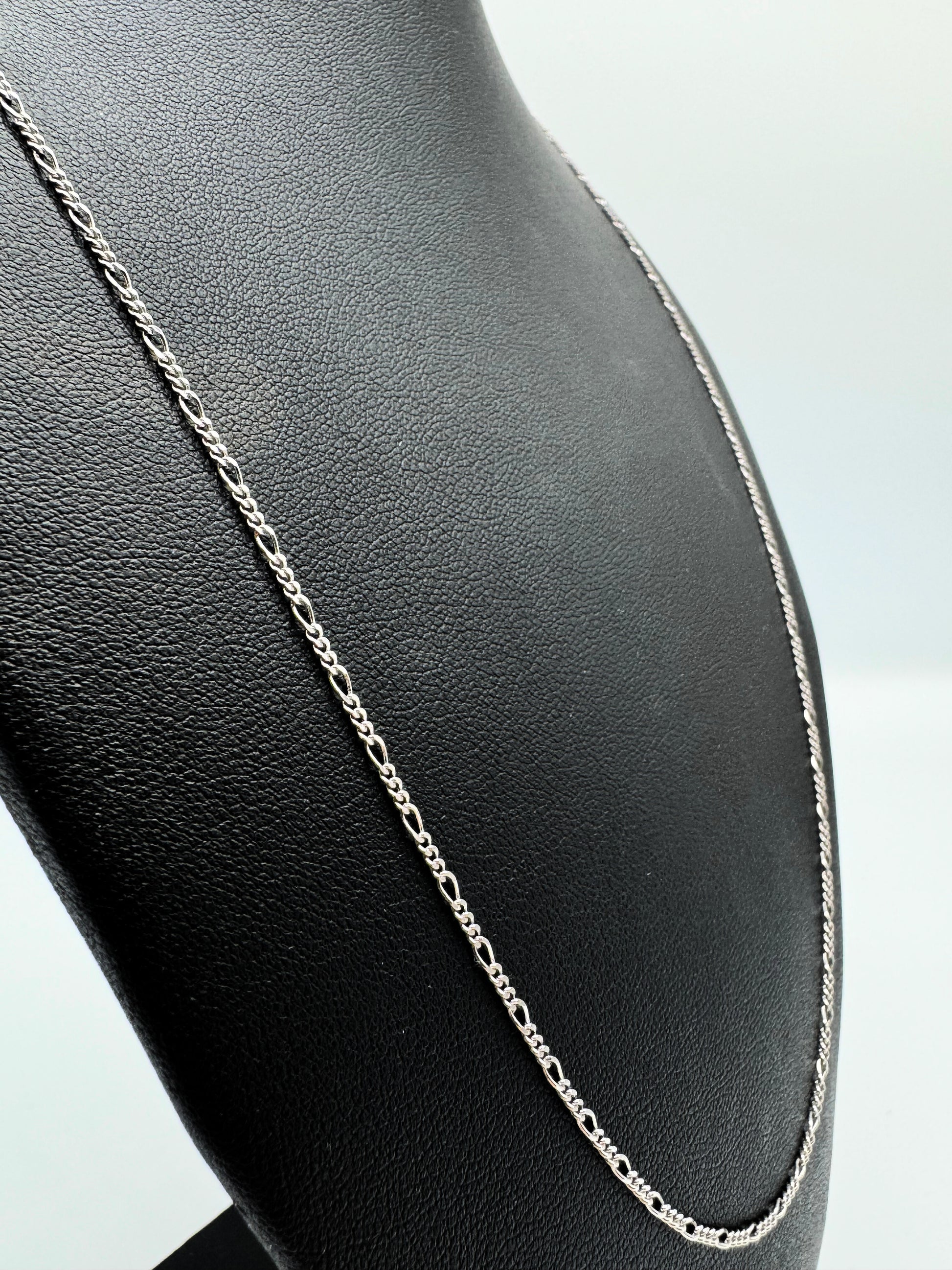 Elegante Figaro-Kette aus 925er Silber mit Diamond-Cut, präsentiert auf einer schwarzen Leder-Schmuckpuppe. Hochwertige, filigrane Glieder mit polierter Oberfläche sorgen für einen edlen Look. Diese Silberkette ist sowohl für Damen als auch Herren geeignet und ideal als modisches Accessoire oder Geschenk. Perfekt für den Alltag oder besondere Anlässe.