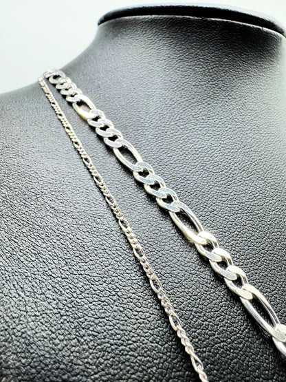 Feine Figaro-Kette aus 925er Sterling Silber mit hochwertigem Diamond-Cut, präsentiert auf einer edlen schwarzen Leder-Schmuckpuppe. Die glänzende, filigrane Gliederkette überzeugt mit ihrem zeitlosen Design und luxuriösem Finish. Perfekt als modisches Accessoire für Damen und Herren, ideal für den Alltag oder besondere Anlässe.