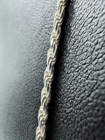 Detailaufnahme einer hochwertigen Kordelkette aus 925er Sterlingsilber – fein geflochtenes, robustes Design mit glänzendem Finish. Zeitlose Unisex-Silberkette für Damen und Herren, elegant präsentiert auf strukturiertem schwarzem Hintergrund